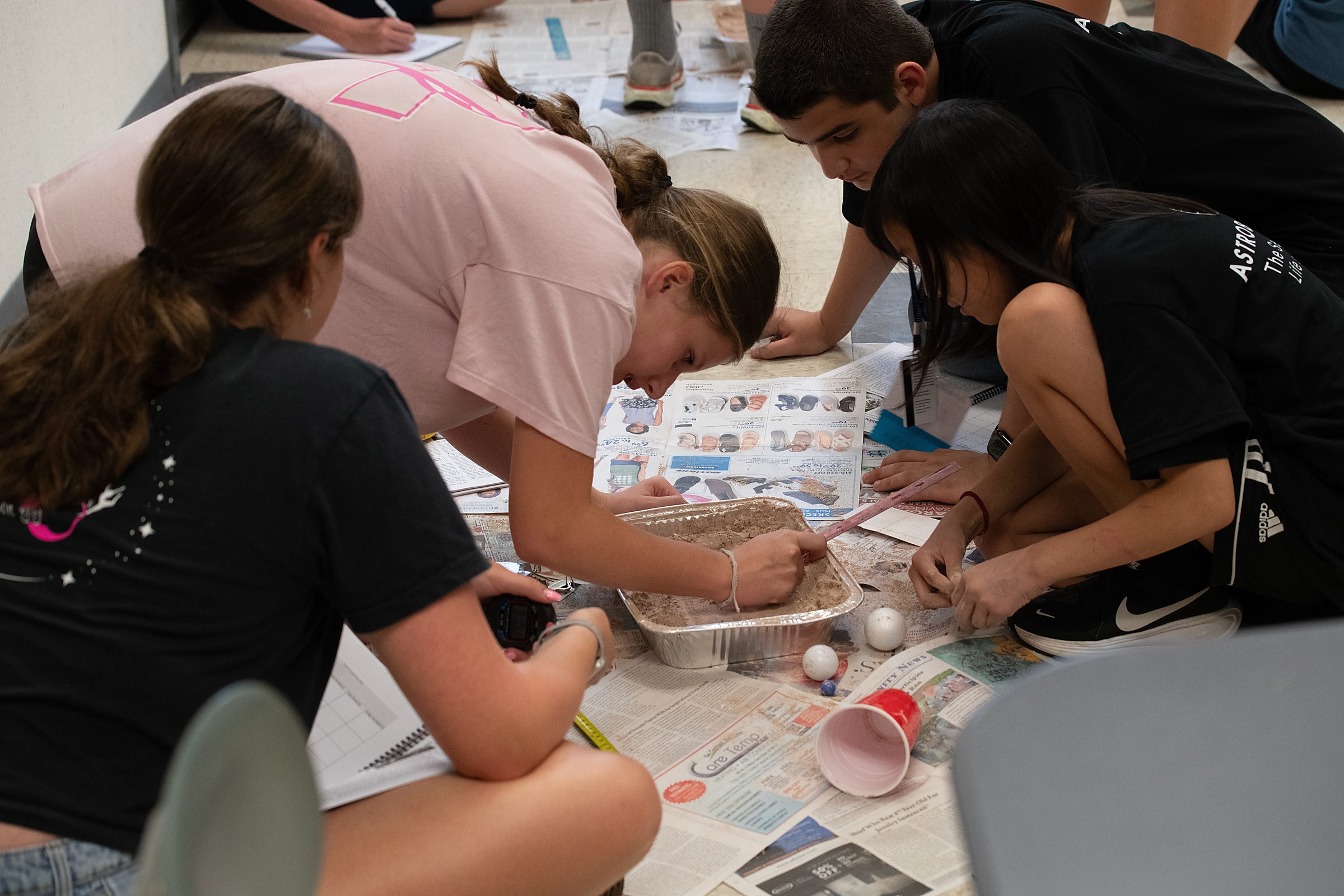 Students simulate the formation of craters and precisely measure results.